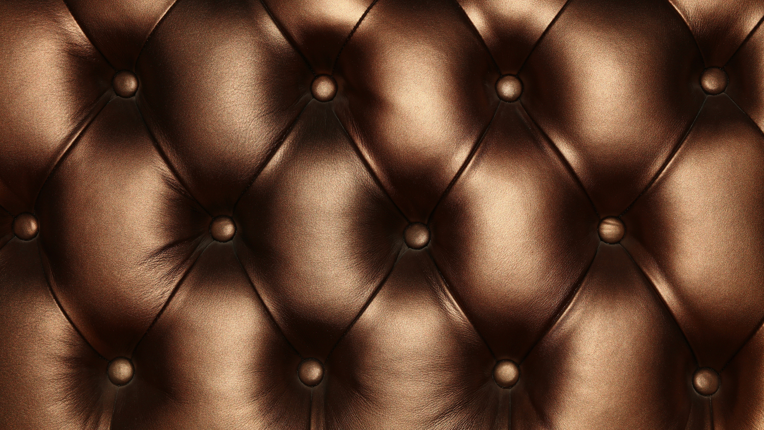 Photograph of a bronze or copper color tufted sofa 